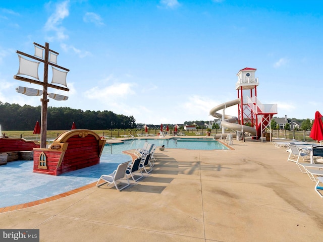 view of swimming pool featuring a patio and a water slide