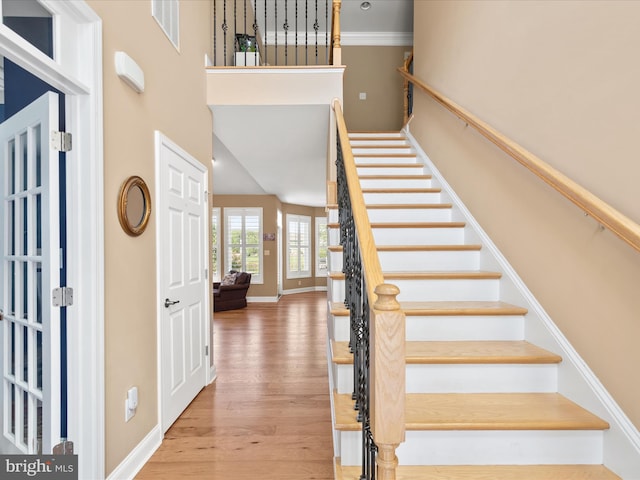 foyer with wood-type flooring and crown molding