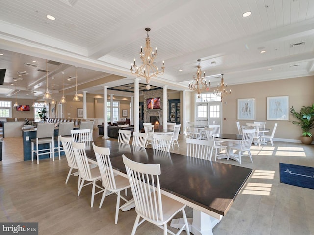 dining space with wood-type flooring, beamed ceiling, and a notable chandelier