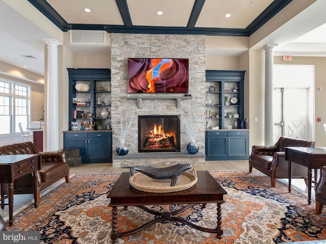 living room featuring a fireplace, crown molding, and ornate columns