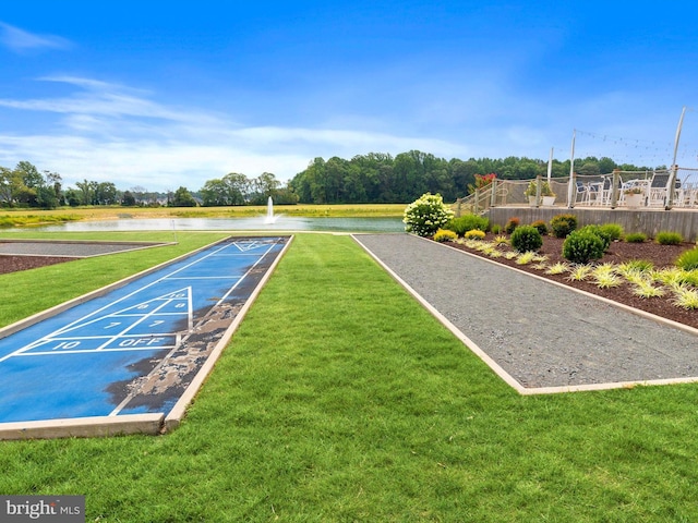 view of community with a lawn and a water view