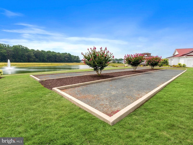 view of home's community featuring a lawn and a water view