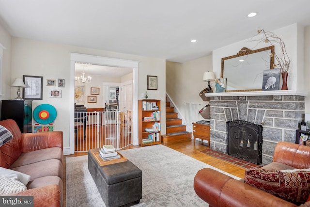 living room with a fireplace, hardwood / wood-style floors, and a chandelier