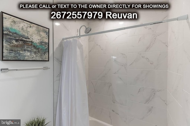 bathroom with shower / bath combo with shower curtain