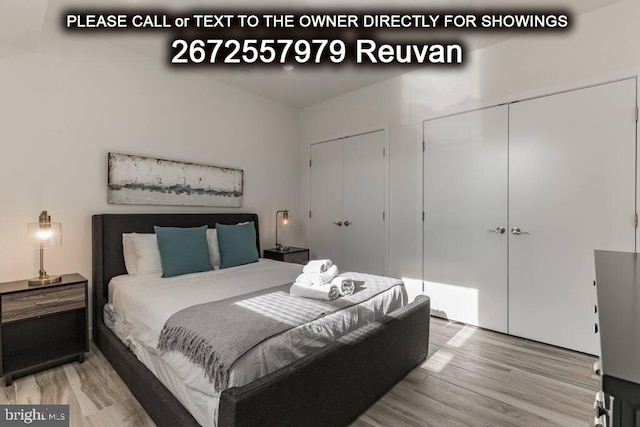 bedroom featuring multiple closets and hardwood / wood-style flooring