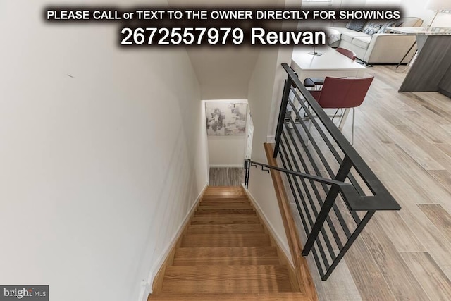 staircase with hardwood / wood-style floors