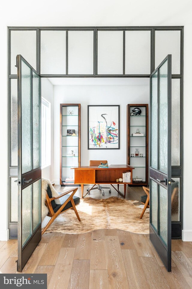 living room with a tray ceiling and light hardwood / wood-style floors