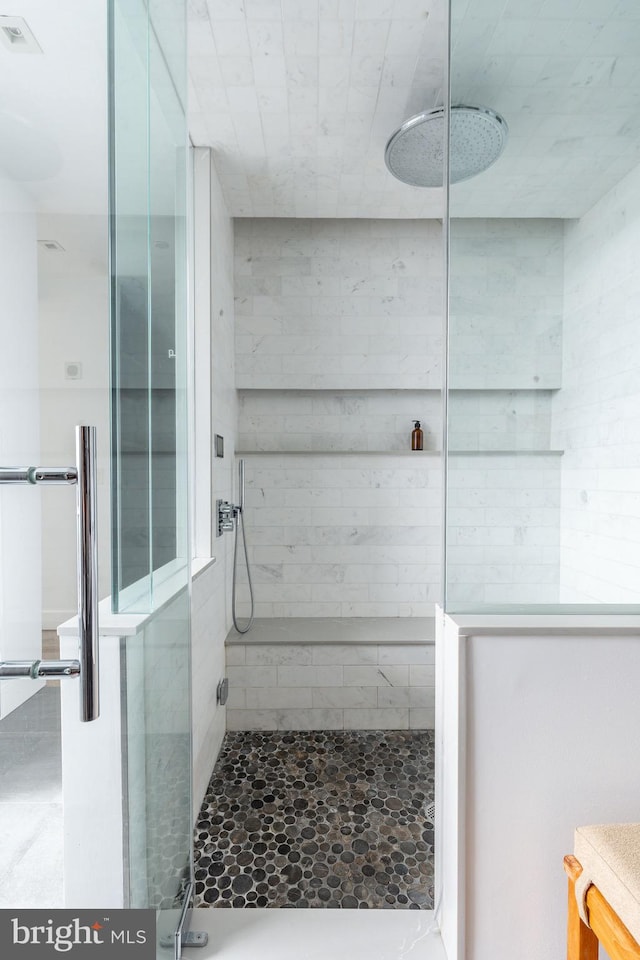 bathroom featuring a tile shower and vanity