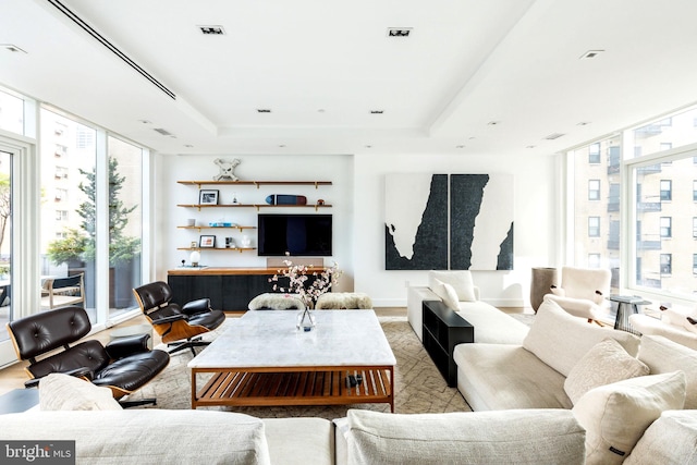 living room featuring expansive windows and a tray ceiling