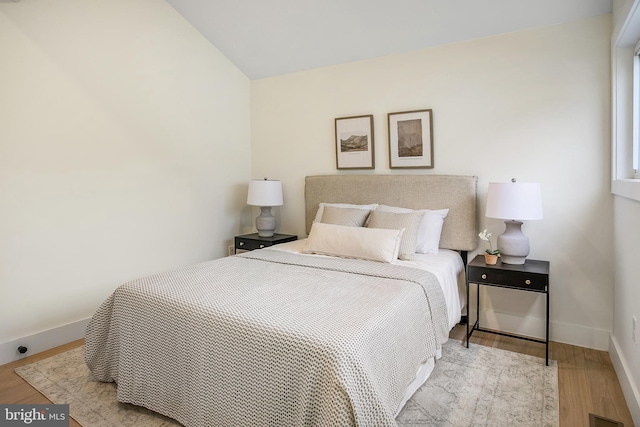 bedroom featuring light hardwood / wood-style floors and vaulted ceiling