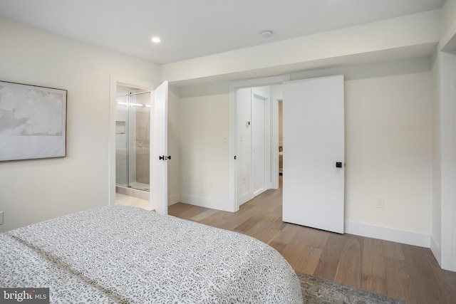 bedroom with connected bathroom and light hardwood / wood-style flooring