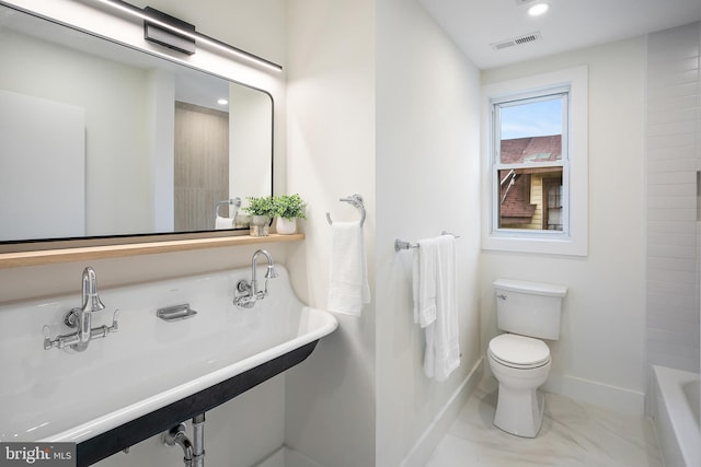 bathroom featuring a bath, toilet, and sink