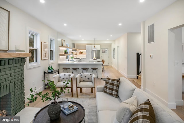 living room with a fireplace and light hardwood / wood-style flooring