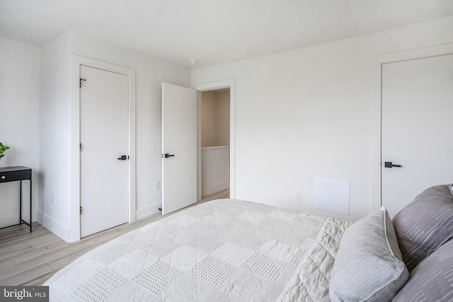 bedroom with light wood-type flooring and baseboards