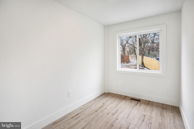 spare room with light wood-style flooring, baseboards, and visible vents