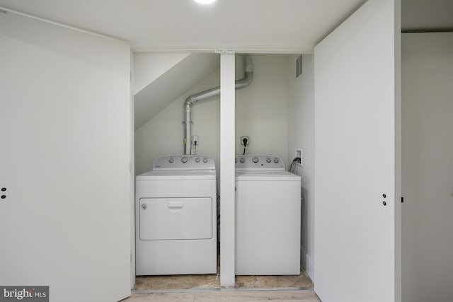 laundry area with laundry area, washing machine and dryer, and visible vents