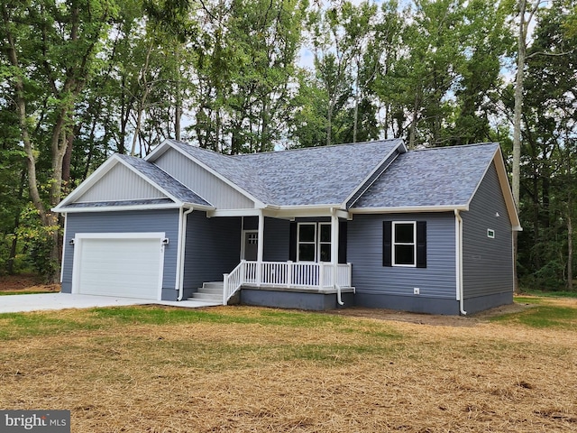 view of front of home featuring a front lawn, a porch, and a garage