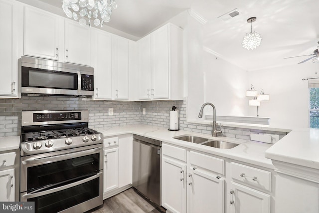 kitchen with light wood-type flooring, sink, white cabinetry, appliances with stainless steel finishes, and light stone countertops