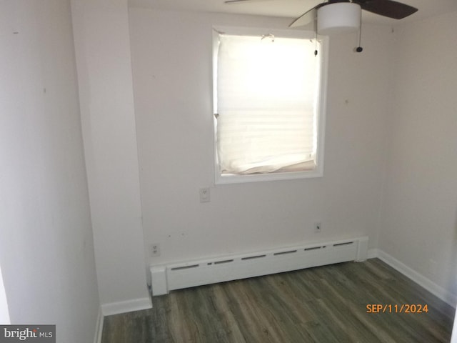 empty room with ceiling fan, baseboard heating, and dark wood-type flooring