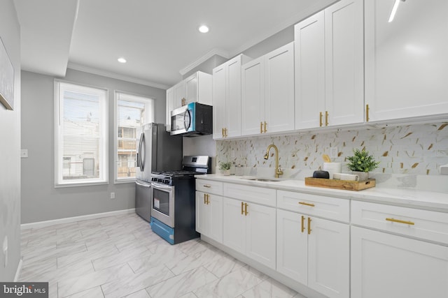 kitchen with backsplash, stainless steel appliances, white cabinetry, and sink