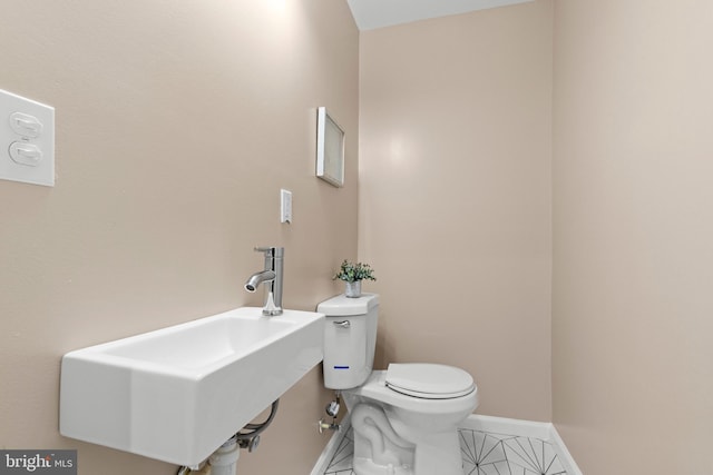 bathroom featuring toilet, sink, and tile patterned floors