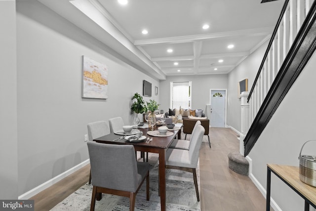 dining space featuring beam ceiling, coffered ceiling, and hardwood / wood-style floors