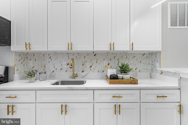 kitchen with light stone counters and white cabinetry