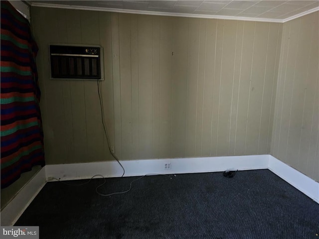 spare room featuring ornamental molding and wood walls