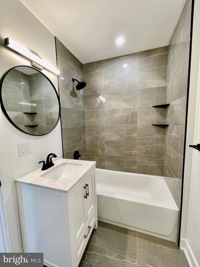 bathroom with tiled shower / bath and vanity