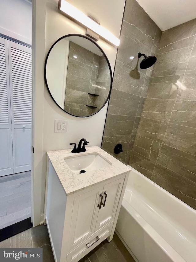 bathroom featuring tiled shower / bath combo, vanity, and tile patterned floors