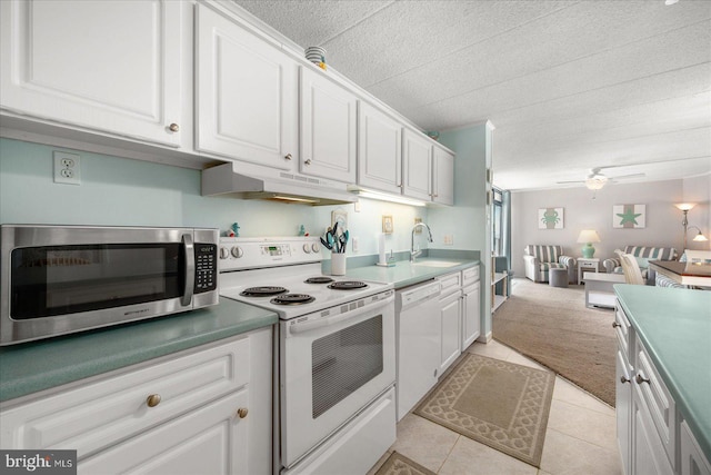 kitchen with ceiling fan, sink, white appliances, white cabinetry, and light colored carpet