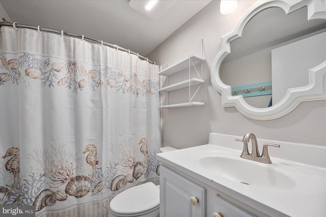 bathroom featuring walk in shower, vanity, and toilet