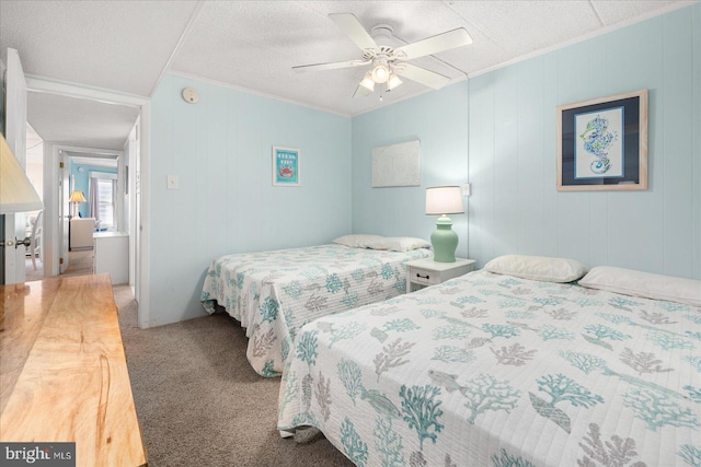 carpeted bedroom featuring ceiling fan, a textured ceiling, and ornamental molding