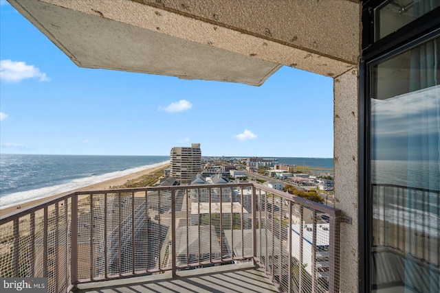 balcony featuring a water view and a beach view