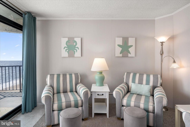 living area featuring a textured ceiling, crown molding, and a water view