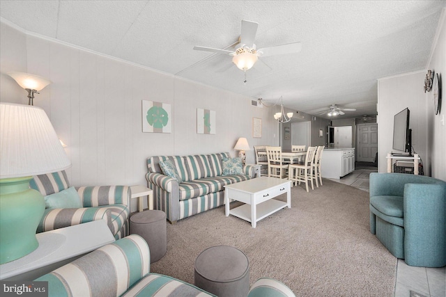 carpeted living room with ceiling fan with notable chandelier and a textured ceiling