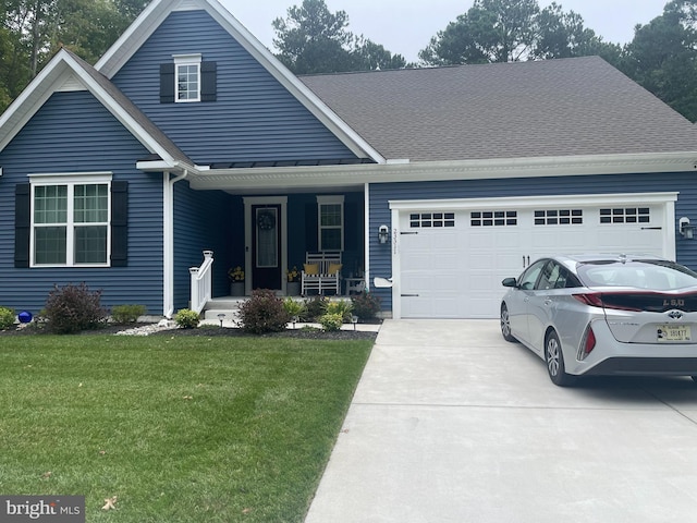 view of front of home with covered porch, a front yard, and a garage