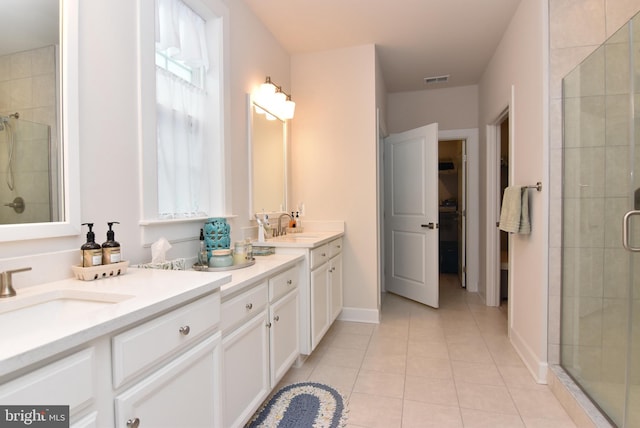 bathroom with tile patterned flooring, a shower with door, and vanity