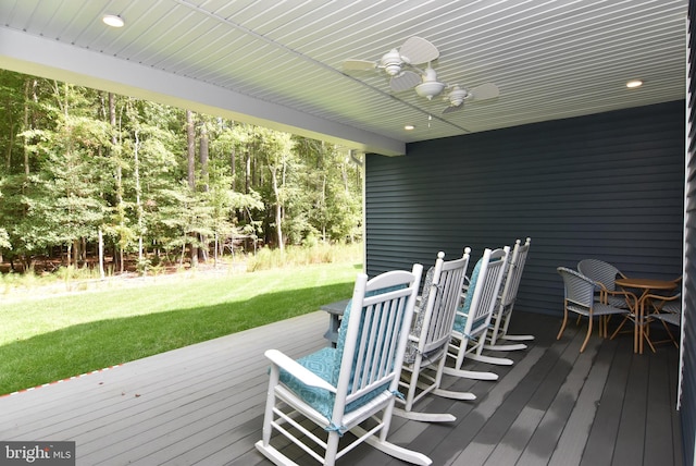 wooden deck featuring ceiling fan and a lawn