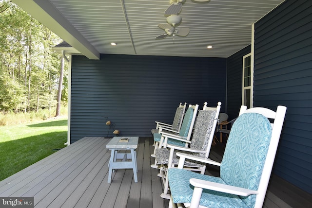 deck featuring ceiling fan and a lawn