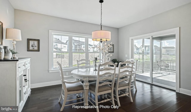 dining area featuring dark wood-type flooring and a chandelier