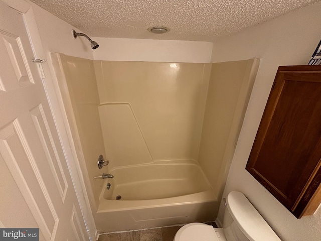 bathroom featuring shower / tub combination, a textured ceiling, and toilet