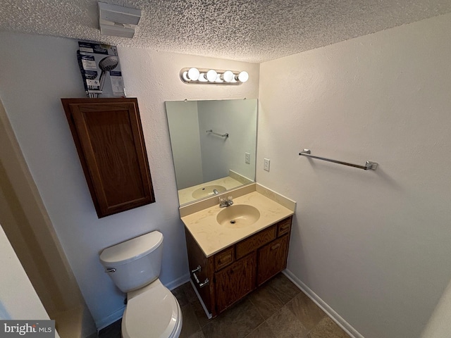 bathroom with tile patterned floors, a textured ceiling, vanity, and toilet