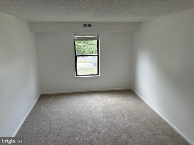 unfurnished room featuring a textured ceiling and carpet flooring