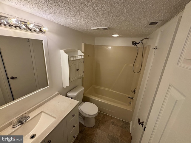 full bathroom featuring a textured ceiling, shower / washtub combination, vanity, and toilet