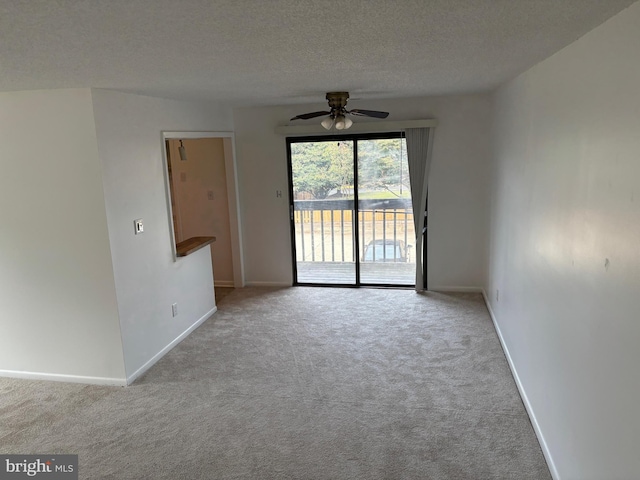 carpeted spare room featuring ceiling fan and a textured ceiling