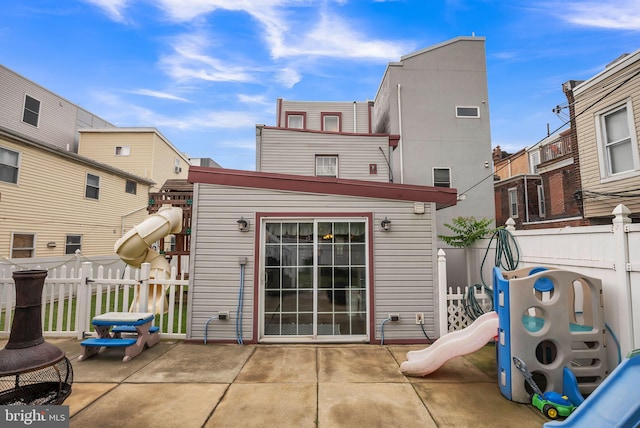 rear view of house with a patio and a playground