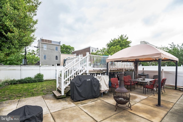 view of patio / terrace featuring area for grilling, a deck, a fire pit, and a gazebo