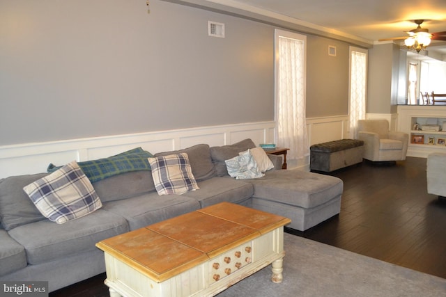 living room featuring ceiling fan and dark wood-type flooring