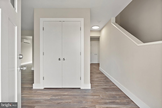 corridor with hardwood / wood-style flooring and a wall mounted air conditioner